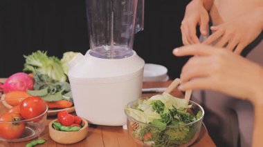 Kadın, sağlıklı yemek hazırlamak için mutfak tezgahında sebze kesiyor.