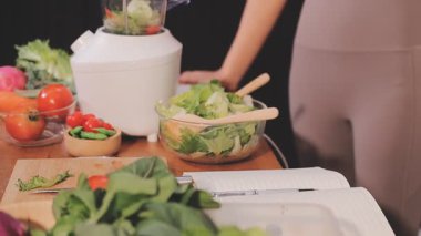 Kadın, sağlıklı yemek hazırlamak için mutfak tezgahında sebze kesiyor.