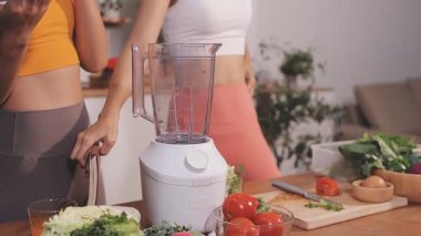 Kadın, sağlıklı yemek hazırlamak için mutfak tezgahında sebze kesiyor.