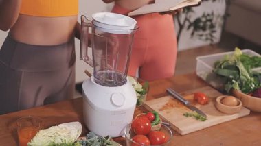 Kadın, sağlıklı yemek hazırlamak için mutfak tezgahında sebze kesiyor.