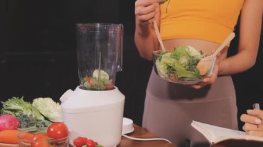 Kadın, sağlıklı yemek hazırlamak için mutfak tezgahında sebze kesiyor.