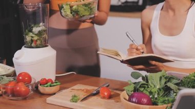 Kadın, sağlıklı yemek hazırlamak için mutfak tezgahında sebze kesiyor.