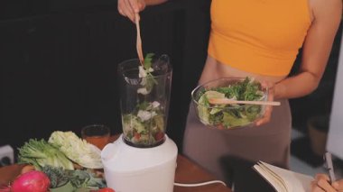 Kadın, sağlıklı yemek hazırlamak için mutfak tezgahında sebze kesiyor.