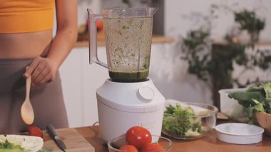 Kadın, sağlıklı yemek hazırlamak için mutfak tezgahında sebze kesiyor.