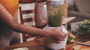 Kadın, sağlıklı yemek hazırlamak için mutfak tezgahında sebze kesiyor.