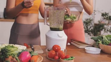 Kadın, sağlıklı yemek hazırlamak için mutfak tezgahında sebze kesiyor.