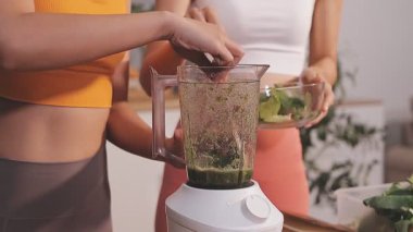 Kadın, sağlıklı yemek hazırlamak için mutfak tezgahında sebze kesiyor.