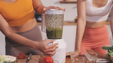 Kadın, sağlıklı yemek hazırlamak için mutfak tezgahında sebze kesiyor.