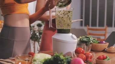 Kadın, sağlıklı yemek hazırlamak için mutfak tezgahında sebze kesiyor.