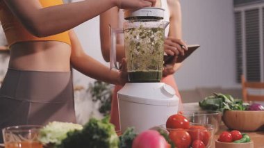 Kadın, sağlıklı yemek hazırlamak için mutfak tezgahında sebze kesiyor.