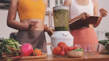 Kadın, sağlıklı yemek hazırlamak için mutfak tezgahında sebze kesiyor.