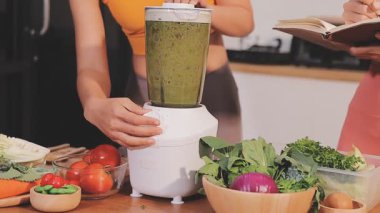 Kadın, sağlıklı yemek hazırlamak için mutfak tezgahında sebze kesiyor.