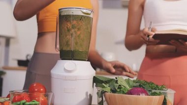 Kadın, sağlıklı yemek hazırlamak için mutfak tezgahında sebze kesiyor.