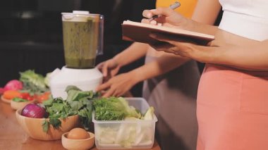 Kadın, sağlıklı yemek hazırlamak için mutfak tezgahında sebze kesiyor.