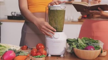 Kadın, sağlıklı yemek hazırlamak için mutfak tezgahında sebze kesiyor.