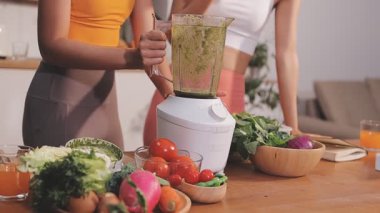 Kadın, sağlıklı yemek hazırlamak için mutfak tezgahında sebze kesiyor.