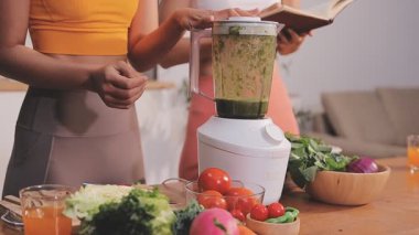 Kadın, sağlıklı yemek hazırlamak için mutfak tezgahında sebze kesiyor.