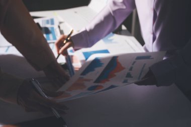 Above table with finance papers, graphs and big data during teamwork meeting with accounting or marketing team discussing budget, strategy or growth development. Closeup of SEO team doing research