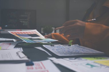 Uxui tasarımcılarından oluşan bir ekip bilgisayar ekranını işaret ederek ofiste yeni mobil uygulama tasarımını tartışıyor.