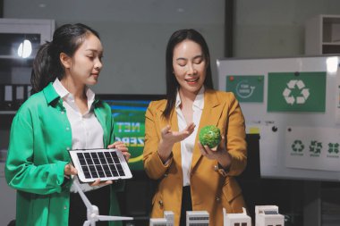 İki iş adamı ekibi güneş pili ve rüzgar türbini jeneratörü ile sürdürülebilir ve yenilenebilir temiz enerji ürünü, CO2 emisyonları küresel ısınma projesini planlıyor ve tartışıyor.