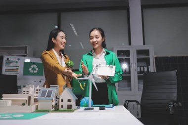 İki iş adamı ekibi güneş pili ve rüzgar türbini jeneratörü ile sürdürülebilir ve yenilenebilir temiz enerji ürünü, CO2 emisyonları küresel ısınma projesini planlıyor ve tartışıyor.