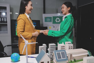 İki iş adamı ekibi güneş pili ve rüzgar türbini jeneratörü ile sürdürülebilir ve yenilenebilir temiz enerji ürünü, CO2 emisyonları küresel ısınma projesini planlıyor ve tartışıyor.