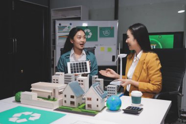 İki iş adamı ekibi güneş pili ve rüzgar türbini jeneratörü ile sürdürülebilir ve yenilenebilir temiz enerji ürünü, CO2 emisyonları küresel ısınma projesini planlıyor ve tartışıyor.