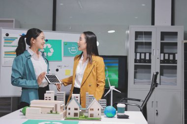 İki iş adamı ekibi güneş pili ve rüzgar türbini jeneratörü ile sürdürülebilir ve yenilenebilir temiz enerji ürünü, CO2 emisyonları küresel ısınma projesini planlıyor ve tartışıyor.