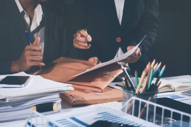 İş, finans ve hukuki işler kavramları için masanın üzerindeki bir sözleşmeyi veya yasal belgeyi inceleyen kişinin ellerinin profesyonel fotoğrafı