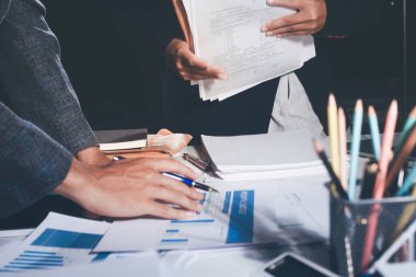 İş, finans ve hukuki işler kavramları için masanın üzerindeki bir sözleşmeyi veya yasal belgeyi inceleyen kişinin ellerinin profesyonel fotoğrafı