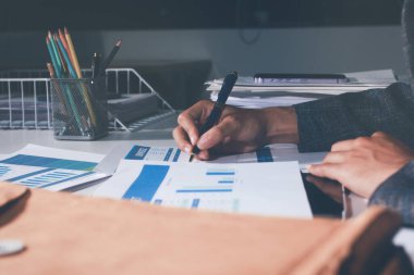 İş, finans ve hukuki işler kavramları için masanın üzerindeki bir sözleşmeyi veya yasal belgeyi inceleyen kişinin ellerinin profesyonel fotoğrafı