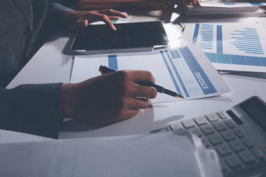 İş, finans ve hukuki işler kavramları için masanın üzerindeki bir sözleşmeyi veya yasal belgeyi inceleyen kişinin ellerinin profesyonel fotoğrafı