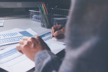 İş, finans ve hukuki işler kavramları için masanın üzerindeki bir sözleşmeyi veya yasal belgeyi inceleyen kişinin ellerinin profesyonel fotoğrafı