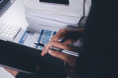 İş, finans ve hukuki işler kavramları için masanın üzerindeki bir sözleşmeyi veya yasal belgeyi inceleyen kişinin ellerinin profesyonel fotoğrafı