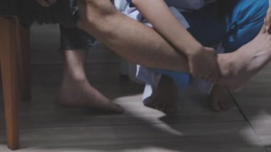 Doktor fizyoterapist yaralı dizini tedavi ediyor, sapını hastanın dizine dayayıp ağrısını kontrol ediyor..