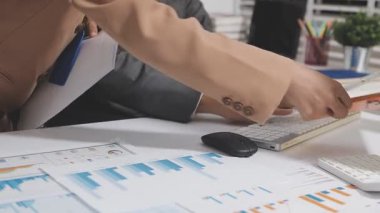 Ofis odasındaki hesap makinesinde finansal yatırım üzerinde çalışan iş adamları veya muhasebecilere yakından bakın..