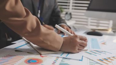 Ofis odasındaki hesap makinesinde finansal yatırım üzerinde çalışan iş adamları veya muhasebecilere yakından bakın..