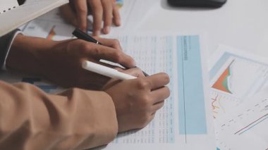 Ofis odasındaki hesap makinesinde finansal yatırım üzerinde çalışan iş adamları veya muhasebecilere yakından bakın..