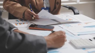 Ofis odasındaki hesap makinesinde finansal yatırım üzerinde çalışan iş adamları veya muhasebecilere yakından bakın..