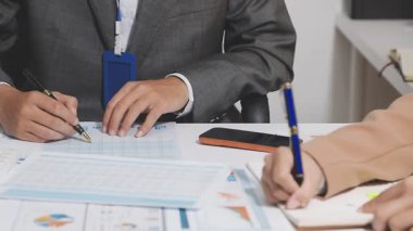 Ofis odasındaki hesap makinesinde finansal yatırım üzerinde çalışan iş adamları veya muhasebecilere yakından bakın..