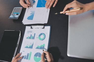 Muhasebe şirketi kazançlı nakit akışı için finansman ve vergilendirme planlaması, ofiste çalışan denetçi ve muhasebeci ekibi, mali verileri ve muhasebe kayıtlarını hesap makinesiyle analiz eder.