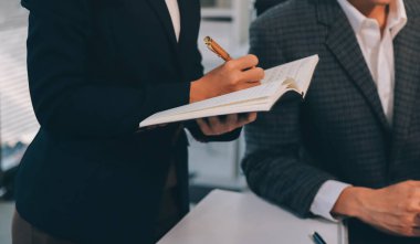 Muhasebe şirketi kazançlı nakit akışı için finansman ve vergilendirme planlaması, ofiste çalışan denetçi ve muhasebeci ekibi, mali verileri ve muhasebe kayıtlarını hesap makinesiyle analiz eder.