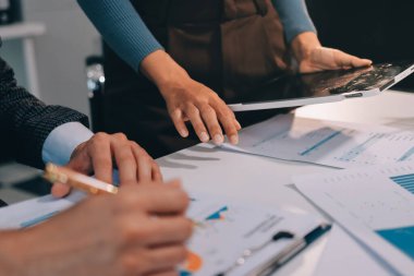 Muhasebe şirketi kazançlı nakit akışı için finansman ve vergilendirme planlaması, ofiste çalışan denetçi ve muhasebeci ekibi, mali verileri ve muhasebe kayıtlarını hesap makinesiyle analiz eder.