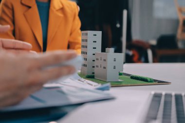 Emlakçı ve müşteri ev, sigorta ya da emlak satın almak için sözleşme imzalarlar. Ev kiralarlar, sigorta yaptırırlar, emlak veya emlak kredisi alırlar..