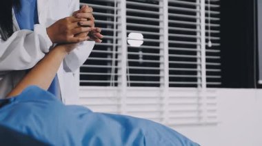 Doktor hastanın bileğini kontrol ediyor.