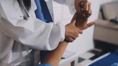 young doctor in white uniform is examining a woman patient with his hand.