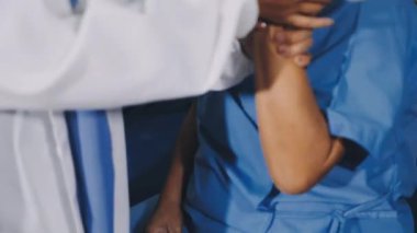 young doctor in uniform and nurse doing exercise with dumbbells in hospital