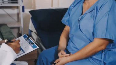 doctor talking with patient while using digital tablet in hospital.