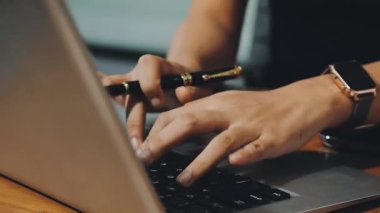 Genç adam ofiste dizüstü bilgisayar kullanıyor..