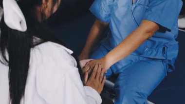 young asian female nurse with patient hand